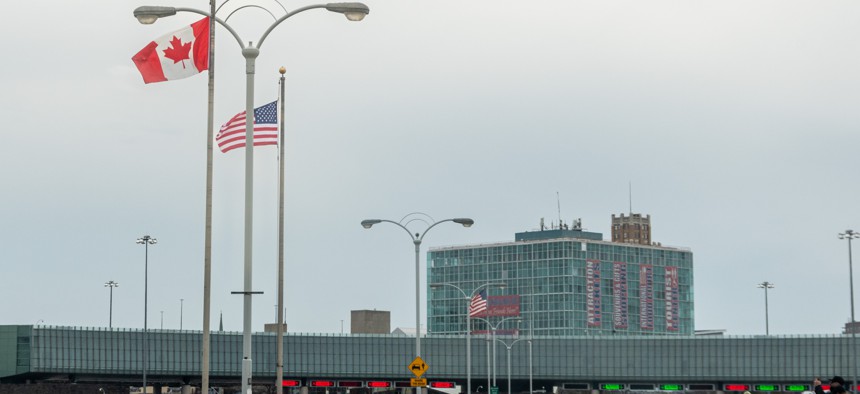 Flags wave at the Ontario New York border crossing. Canadian tourism has gone over a cliff.