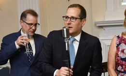 Micah Lasher, center, speaks at a 2022 benefit.