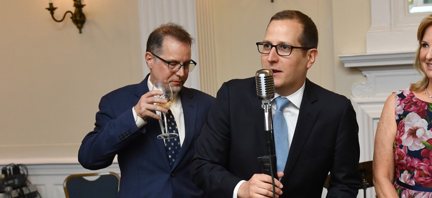 Micah Lasher, center, speaks at a 2022 benefit.