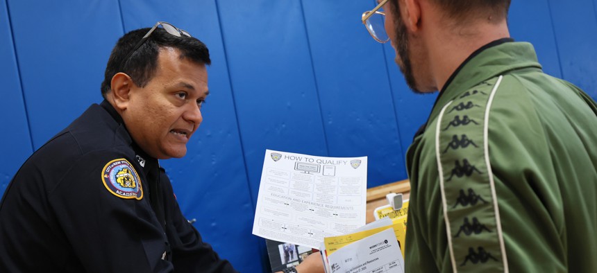 A Department of Correction recruiter shares hiring info at a job fair on Staten Island in March.