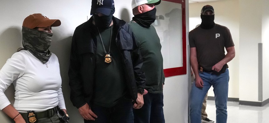 Masked ICE agents wait in the hallways outside immigration court at 26 Federal Plaza on Sept. 8, 2025.