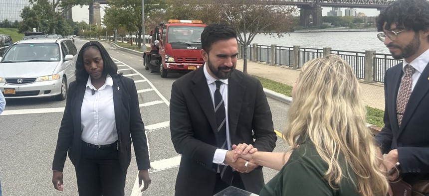 New York City mayoral candidate Zohran Mamdani visits Roosevelt Island, flanked by a member of his security detail.