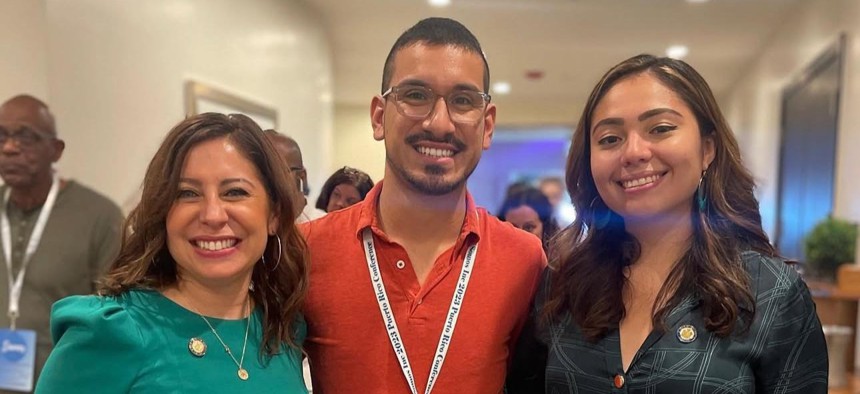 Brian Romero, center, stands with his former boss Assembly Member Jessica González-Rojas, left, and his current boss state Sen. Kristen Gonzalez.