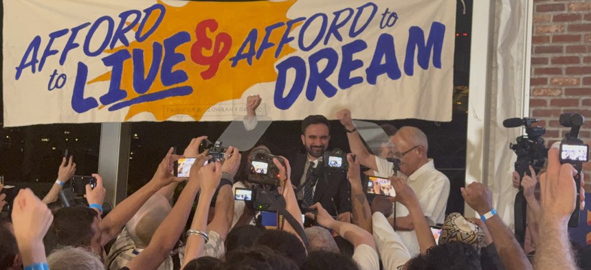Zohran Mamdani speaks under a banner reading “Afford to Live and Afford to Dream” at his primary victory night party in June.