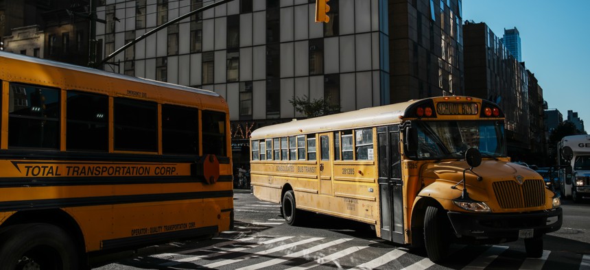 New York City school buses turn a corner in Manhattan.