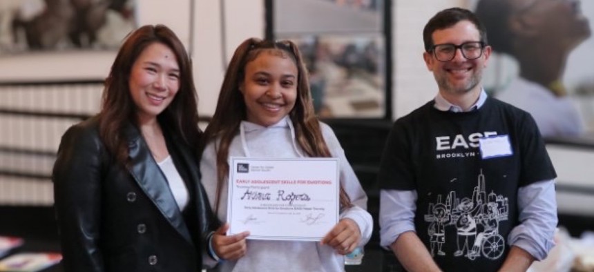 Eva Wong, left, and Adam Brown, right, pose for a photograph with a youth worker who participated in the Early Adolescent Skills in Emotions facilitator training.