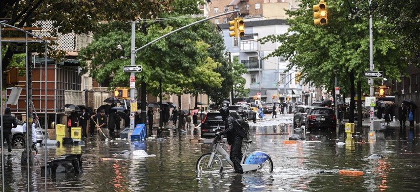 A man tries to ride a Citibike through a flooded street in Brooklyn on Sept. 29, 2023.