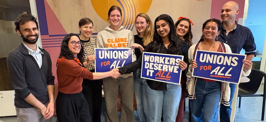 Assembly Member Claire Valdez, second from left, shakes hands with a campaign staffer after they agree to a union contract.