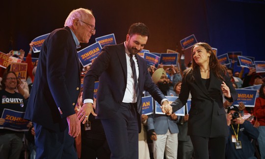 U.S. Sen. Bernie Sanders, Mayor Zohran Mamdani and Rep. Alexandria Ocasio-Cortez hold hands at a Mamdani campaign rally on Oct. 26, 2025.