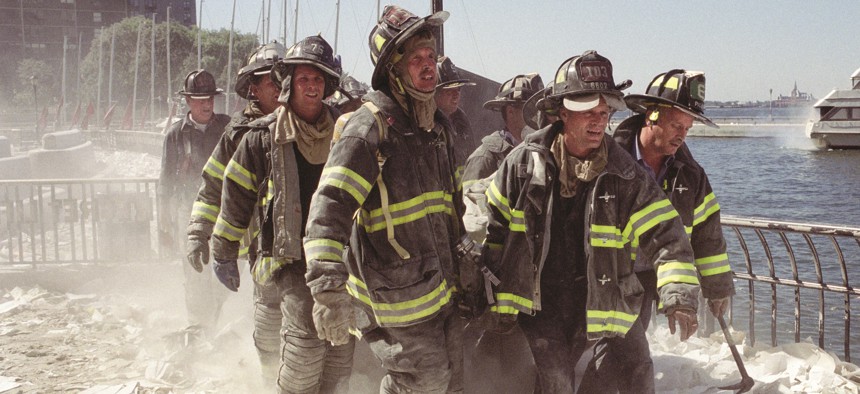 Firefighters carry an injured fellow firefighter away from the World Trade Center site on Sept. 11, 2001.