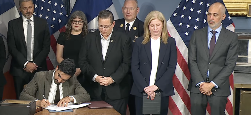 New York City Chief Counsel Ramzi Kassem, right, stands by while Mayor Zohran Mamdani signs 9/11-related executive orders on Sept. 4, 2026.