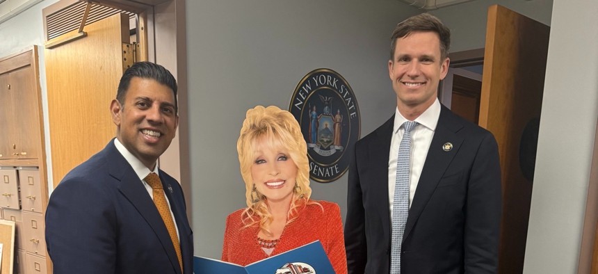State Sens. Jeremy Cooney and Erik Bottcher pose with a lifesize cut-out of President Parton.