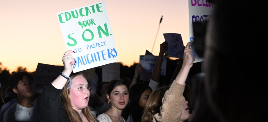 Demonstrators holds signs at a Women’s March protest on Oct. 8, 2026.