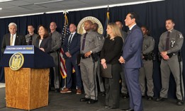Gov. Kathy Hochul touted insurance fraud arrests flanked by law enforcement and other government officials.