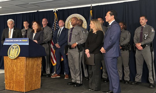 Gov. Kathy Hochul touted insurance fraud arrests flanked by law enforcement and other government officials.